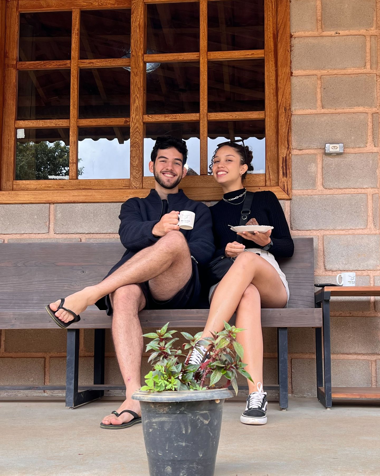 Raissa e Filipe sorrindo, sentados num banco